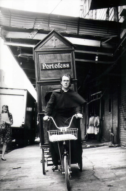 Father Anthony Joseph (aka Joey Skaggs) pedals his Portofess to the 1992 Democratic National Convention, courtesy Joey Skaggs Archive